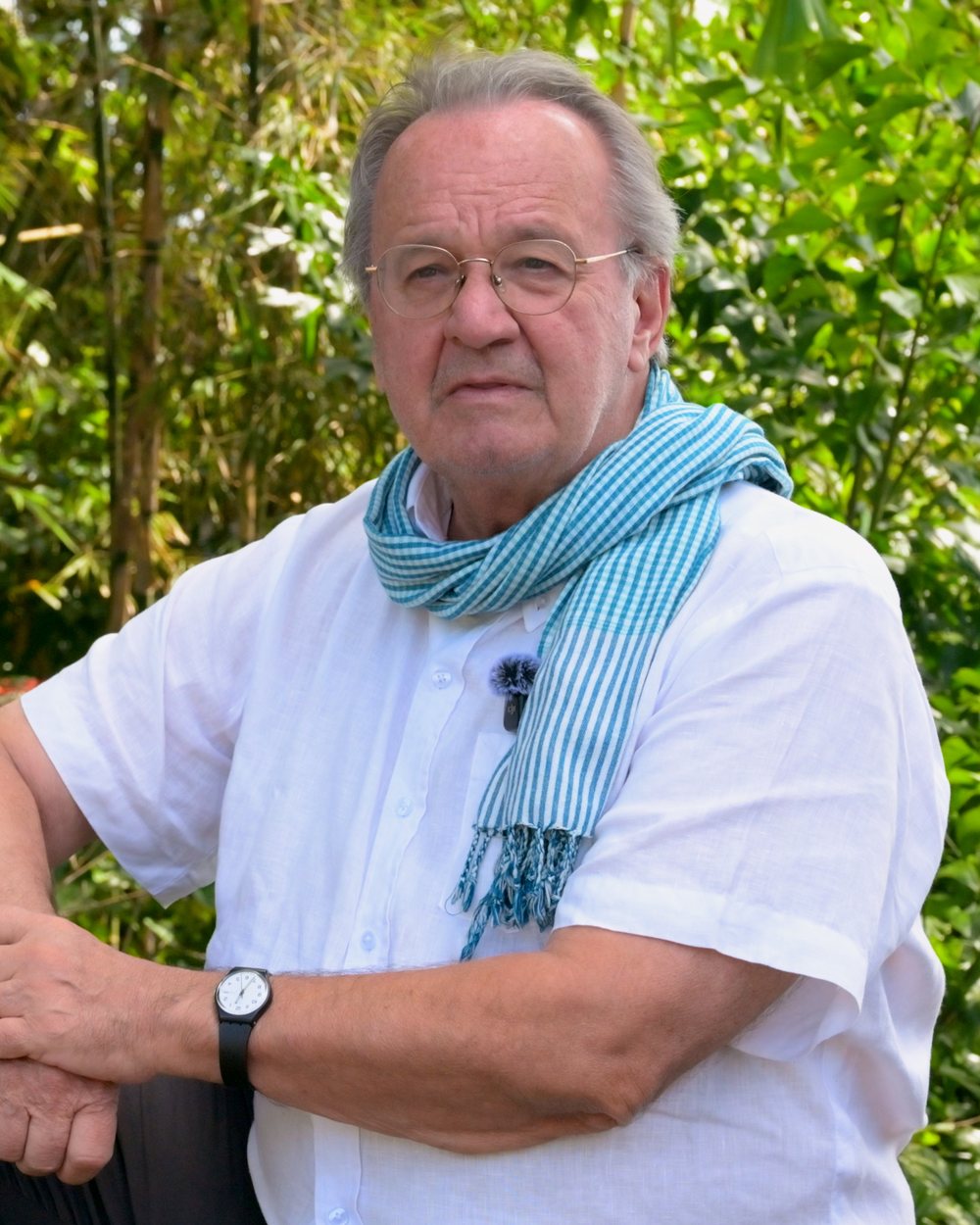 Massimo Sarti, seated outdoors in Vietnam during filming.